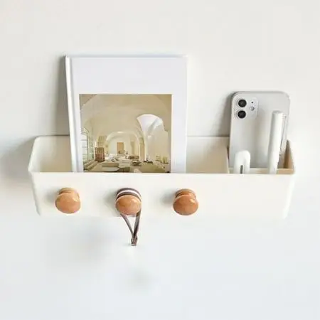 Wall hooks provide free storage in this minimalist small apartment bedroom